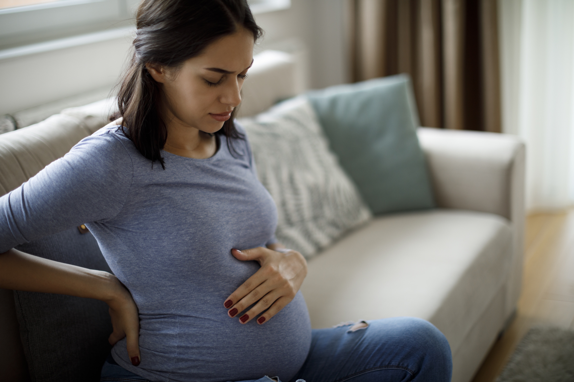 A pregnant woman with hand on her belly